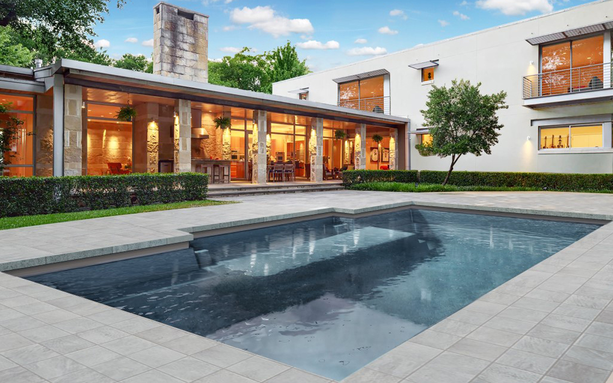 Modern luxury pool design with stone patio
